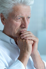 Portrait of thoughtful senior man at home