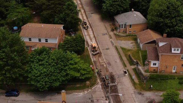 An aerial view of various street machinery working in a Pennsylvania residential neighborhood. Preparing for a re-paving project. Pittsburgh suburbs.  	