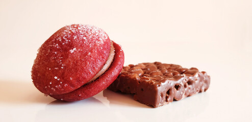 Red round cookies with chocolate and sugar on a square chocolate. Isolated round and square cookie.