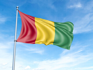 Guinea flag on a pole against a blue sky background.