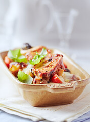 Pork tenderloin baked with Penne pasta, cherry tomatoes, black olives and cheese. Bright background. Close up