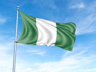 Naklejka na ściany i meble Nigeria flag on a pole against a blue sky background.