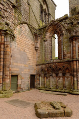 Fototapeta premium Ruins of the Holyrood Abbey near the Palace of Holyroodhouse, the official residence of the British monarch in Scotland