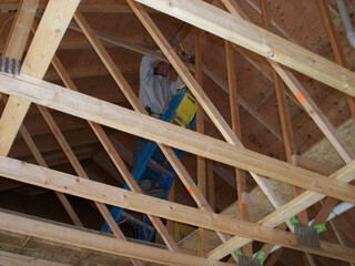 Installation of rafter beams in new house attic. 