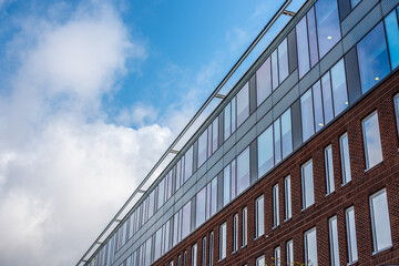 Facade of an office building with blue, cloudy skies in the background