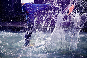 Close-up feet creating splashes of water around themselves