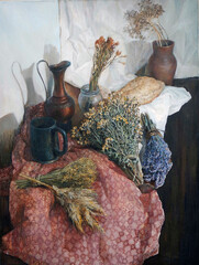 Rustic still life with jugs and dry herbs such as lavender and helichrysum flowers lying on a pale red cloth with a pattern. Oil painting.
