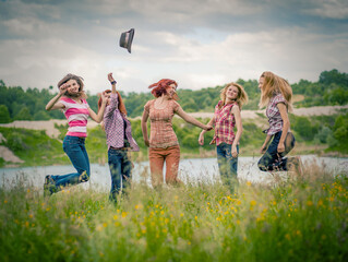 group of happy girls having fun in the meadow