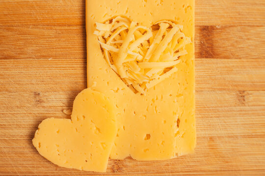 Cheese in the shape of a heart on a wooden Board. Grated cheese in the shape of a heart.