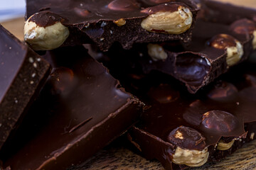 Pieces of black chocolate. Wooden texture background. Sweet food. Food set. High quality photo