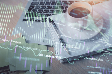 Double exposure of forex chart drawing and desktop with coffee and items on table background. Concept of financial market trading