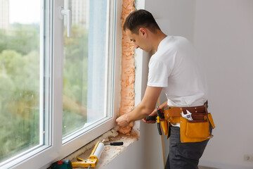 male industrial builder worker at window installation in building construction site