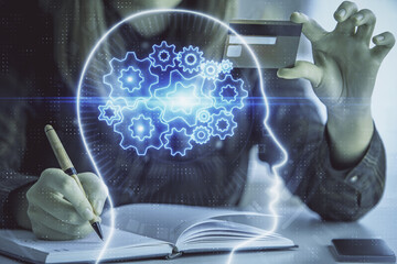 Double exposure of woman on-line shopping holding a credit card and brain hologram drawing. Data...