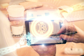 Double exposure of man's hands holding and using a phone and crypto currency blockchain theme drawing.