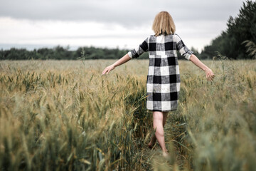 Naklejka na ściany i meble The girl in a gentle dress. On a black field. Gentle and beautiful.