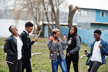 Young millennials african friends walking in city. Happy black people having fun together. Generation Z friendship concept.