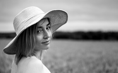 The girl in a delicate dress and hat. In a beautiful field. Gentle and beautiful.