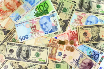 Fototapeta na wymiar Background from dollars and euro bills. One hundred Turkish Lira banknote on other currencies