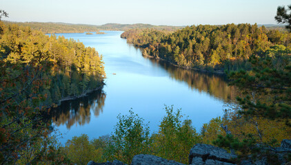 High angle view of a northern Minnesota lake in afternoon light with a small motorboat