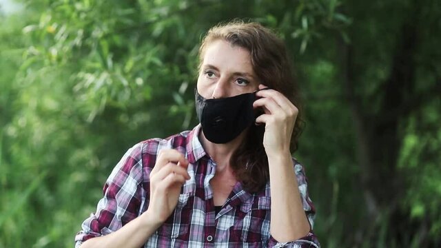woman putting on a face mask