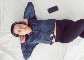 Joven mujer relajada escuchando música con auriculares.