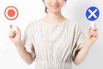 マルバツのプラカードを持つ若い女性