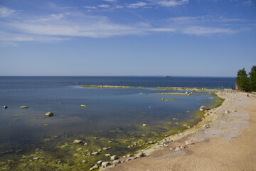 the shore of the bay with stones aerial view. The lighthouse guards the ships from wreck