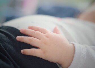 Mano de bebé sobre su estómago. Mano de recién nacido.