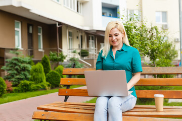 woman searching job with a laptop in an urban park in summer