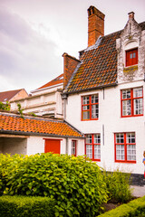 Obraz premium It's Medieval houses with flowers at the windows in the Historic Centre of Bruges, Belgium. part of the UNESCO World Heritage site