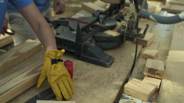 Female Construction Worker Using Speed Square to Draw Line on Wood