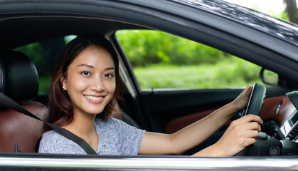 Obraz na płótnie Canvas Beautiful Asian woman smiling and enjoying.driving a car on road for travel