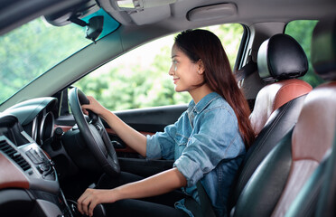 Beautiful Asian woman smiling and enjoying.driving a car on road for travel