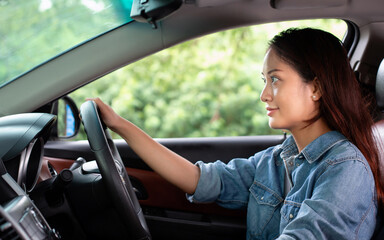 Fototapeta na wymiar Beautiful Asian woman smiling and enjoying.driving a car on road for travel