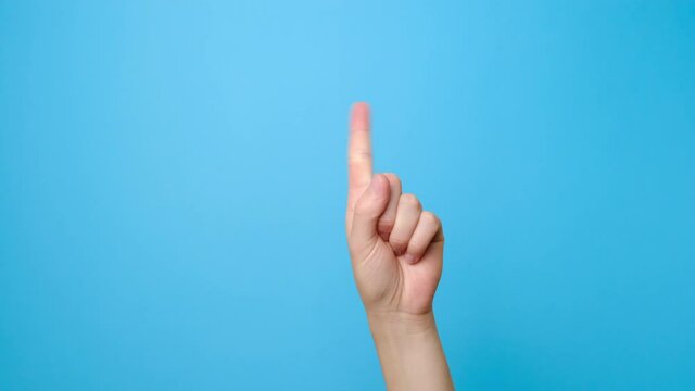 Finger signal. Close up of female hand showing no, isolated on blue studio background with copy space for advertisement. Disapproving gesture. Advertising area, mock up.