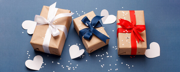 Red, blue and white gift boxes and white heart on classic blue background in the national colors of America, Russia, France or England, the concept of Independence Day, a national holiday