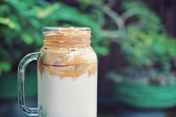 Close up of a glass of dalgona coffee with nature background.