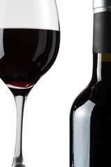 Detail of a glass of red wine next to a bottle on a white background