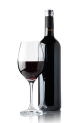 Glass of red wine next to a bottle isolated on white background