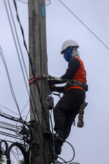 Electricians operate the electrical transmission system on the electricity pole.