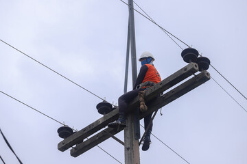 Electricians operate the electrical transmission system on the electricity pole.