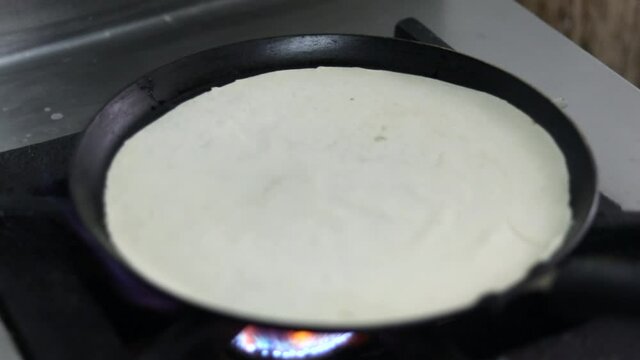 Cooking Indian bread parantha on a huge Indian pan at a street food restaurant. 