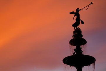 Angel statue with trumpet at sunset
