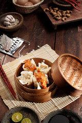 Somay or dimsum. The dim sum is poured with peanut sauce in a steamed bamboo container.