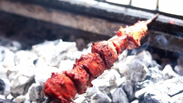 Making masala soya chaap tikka with onions and green mint chutney, served on a white plate.