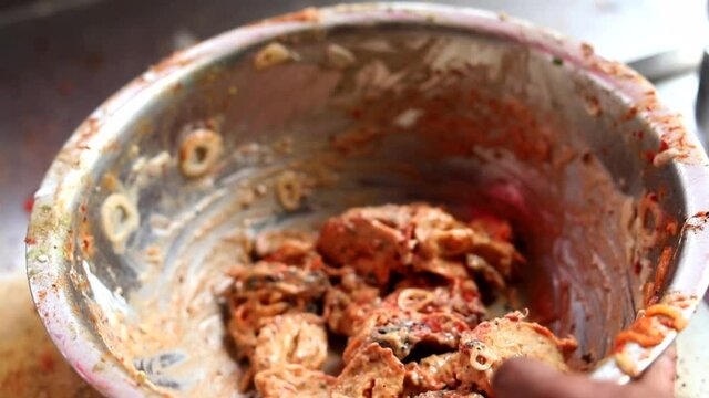 Making masala soya chaap tikka with onions and green mint chutney, served on a white plate.