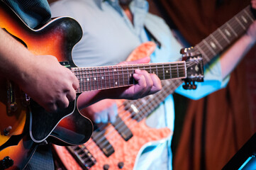 Obraz premium man playing electric guitar and bass 