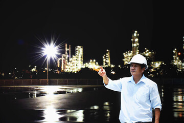 Business People pointing at beautiful shiny light of bulb from factory at night light. Advancement of Industry and Technology concept.