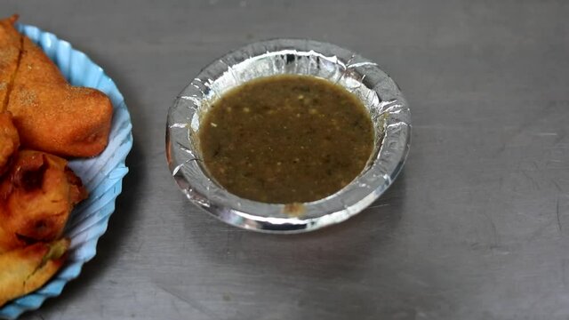 Making indian style fritters or bread pakoda by deep frying vegetables stuffed marinated bread in hot oil kadhai.