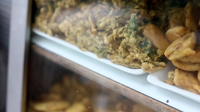 Making indian style fritters or bread pakoda by deep frying vegetables stuffed marinated bread in hot oil kadhai.